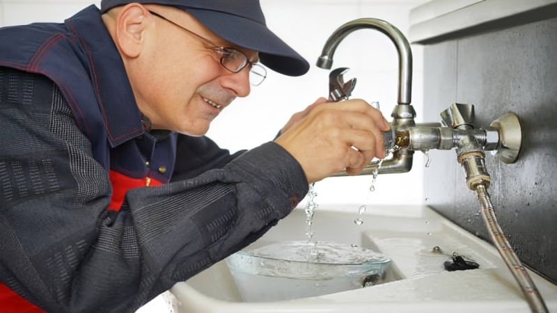 Emergency plumber repairing a burst pipe causing water damage
